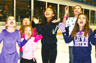 Girls having fun at an ice skating birthday party.