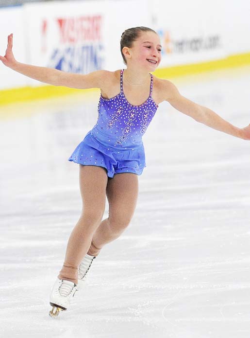 Ice-Skating-Lessons-Purple-Future-opt2 A skater in a purple dress practicing a routine during ice skating lessons.