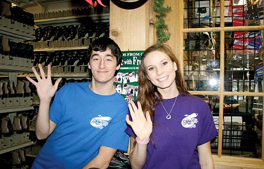 A male and a female employee preparing rental skates for a day of ice skating.