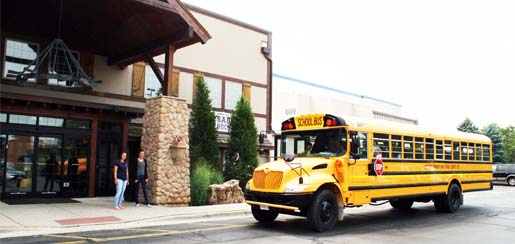 Bus arriving at Rocket Ice Skating Rink full of kids in a summer group outing