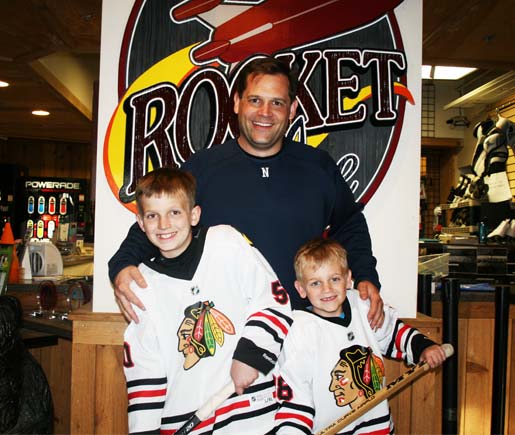 After a Hockey Training Session at Rocket Ice Skating Rink's Stick and Puck a dad poses with his two sons.