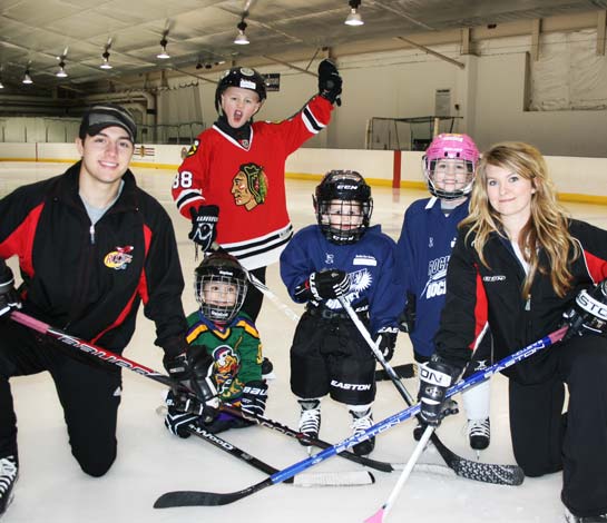 Four hockey players and two instructors posing for a picture after hockey lessons