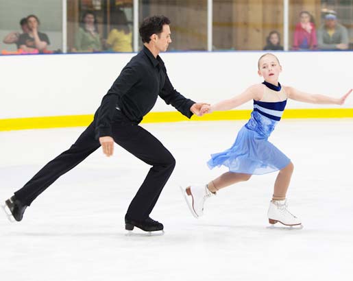 Coach and student practice routine during freestyle ice skating times.