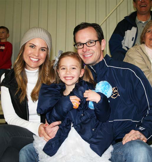 Family of a youth hockey player watches his game from the bleachers