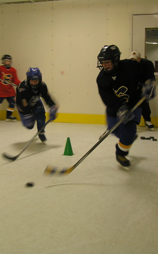 Group of students hockey practice on synthetic ice.