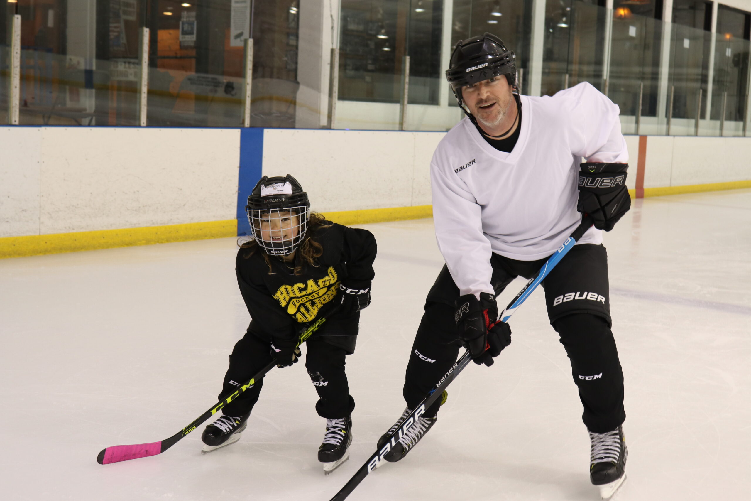 Dad and 8 year old child at Stick & Puck practicing hockey together. Hockey is a lifetime sport for all to enjoy. Great for parents and kids.