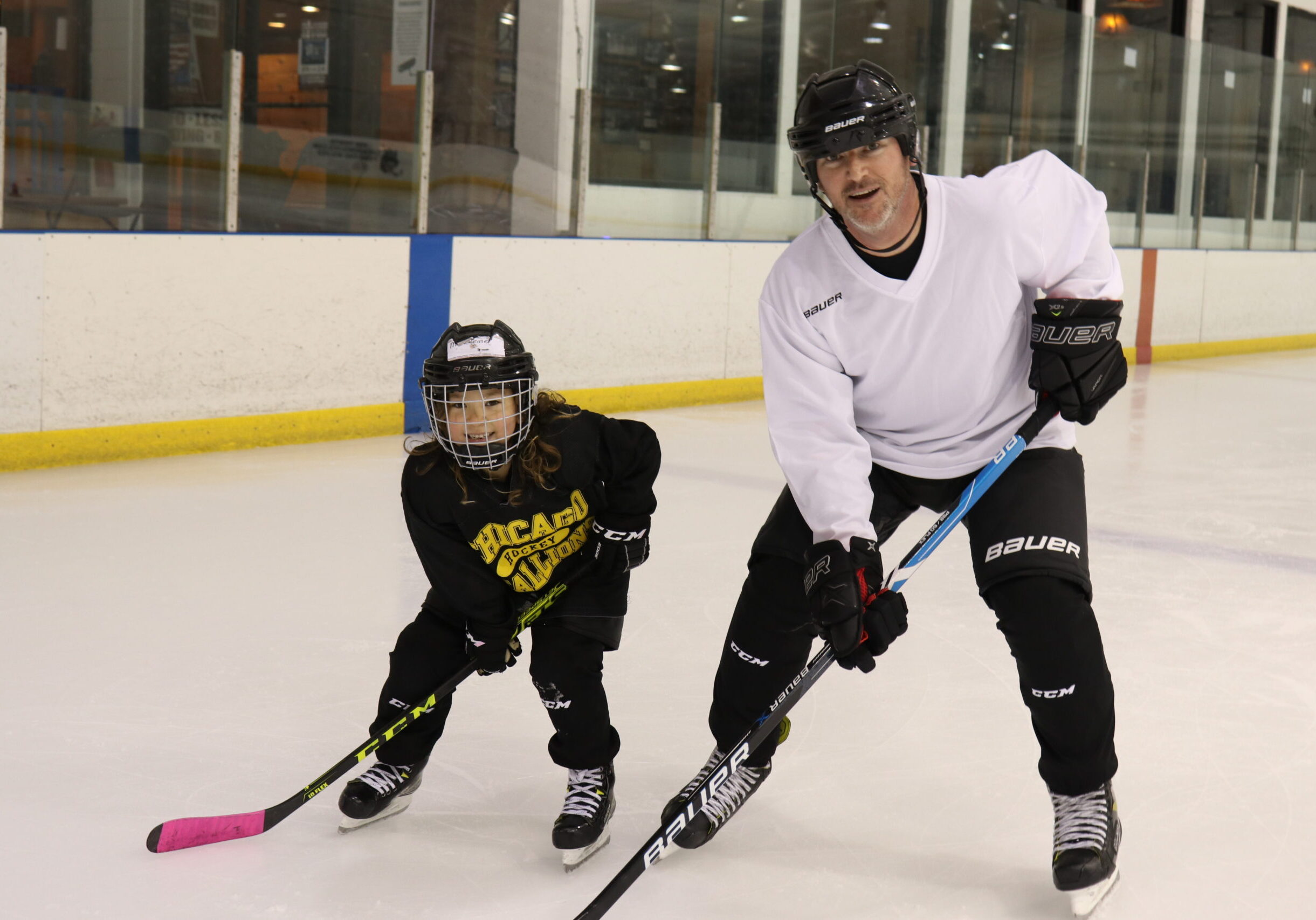 Dad and 8 year old child at Stick & Puck practicing hockey together. Hockey is a lifetime sport for all to enjoy. Great for parents and kids.